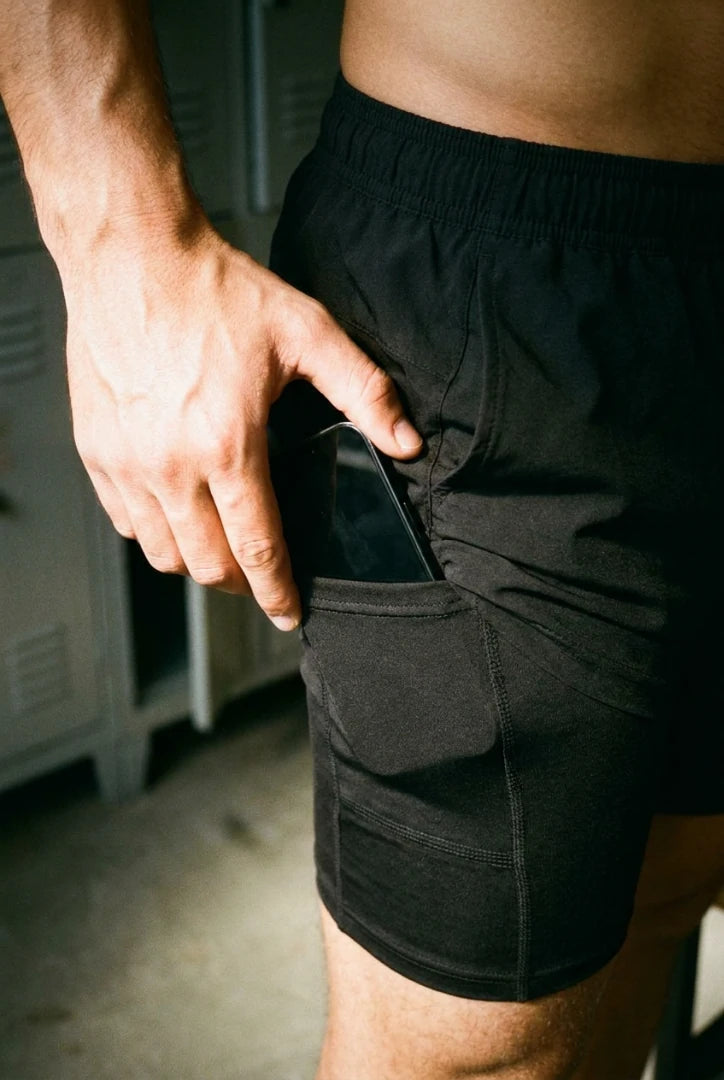 Close de uma mão colocando o celular no bolso interno do forro preto